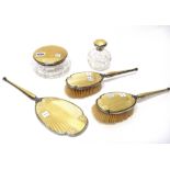 A lady's silver and buff coloured enamel mounted five piece part dressing set, comprising; a powder