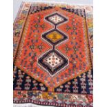A South Persian rug, the madder floral field with three indigo diamonds, matching spandrels, a
