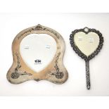 A silver mounted heart shaped mirror, applied with ribbon tied bow and scrolling motifs and fitted