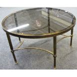 A 20th century glass top circular coffee table on reeded supports, 76cm wide.
