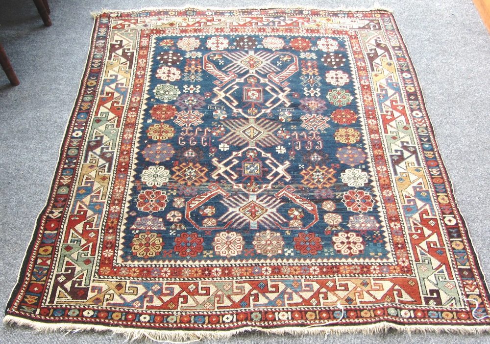 A Shirvan rug, Caucasian, the dark indigo field with three medallions supported by single Talish