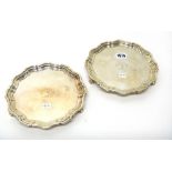 A pair of late Victorian silver shaped circular small salvers, each crest and motto engraved to the