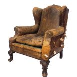 A 19th century leather upholstered wingback armchair on cabriole supports.