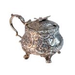 A George III silver mustard pot, of bombe form, embossed with floral, foliate and scrolling