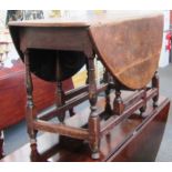 A 17th century oak oval drop flap table on baluster supports, 122cm wide.