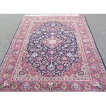 A Kashan rug, Persian, the indigo field with a rose madder medallion, matching spandrels, all with