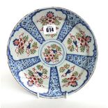 A delft polychrome plate, mid 18th century, painted in blue, green and iron-red with panels of