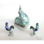 A Herend porcelain group modeled with two rabbits atop a shaped base,