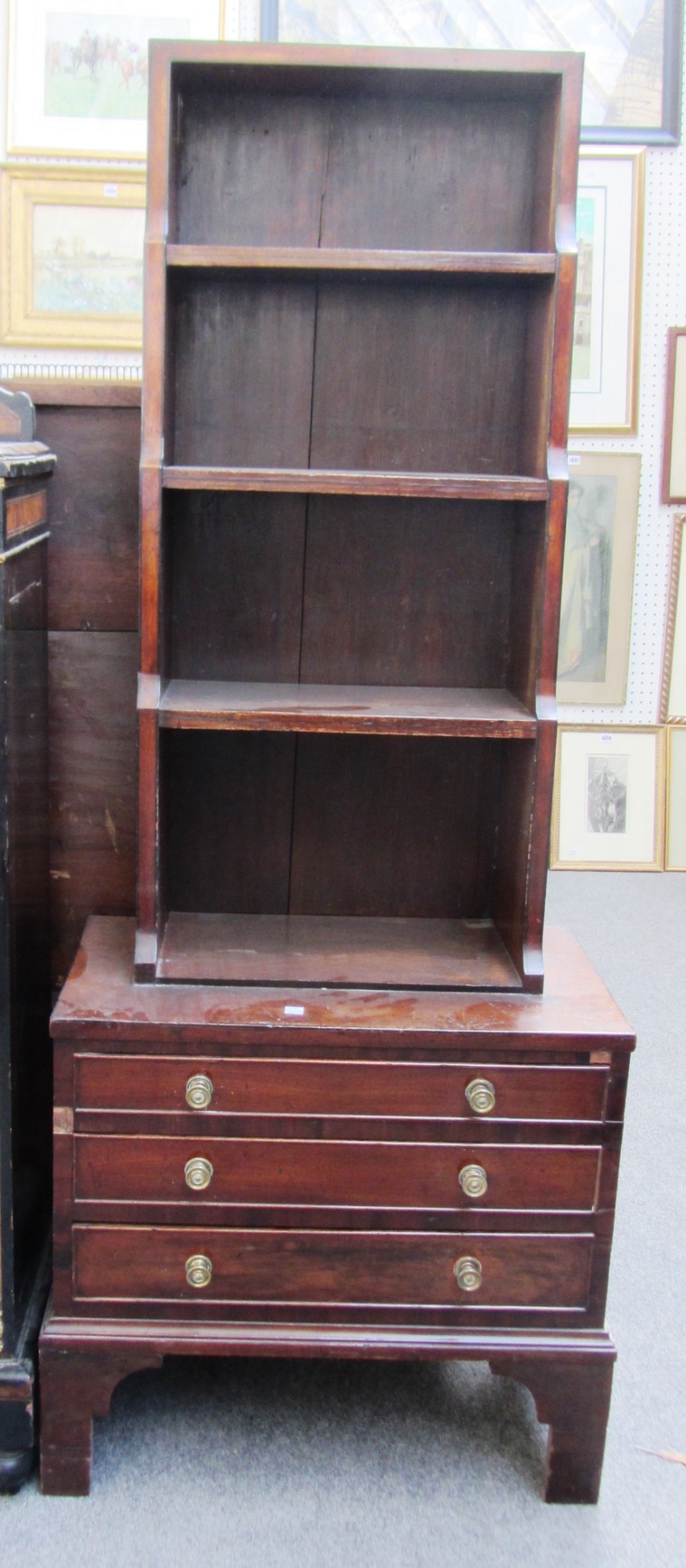 An early 19th century and later mahogany ebony strung waterfall open bookcase on chest with three