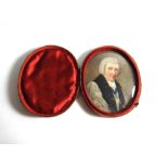 An oval portrait miniature of a clergyman, with grey hair wearing a white surplice and an enameled