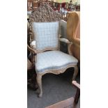 A 19th century stripped and limed beech open armchair with 17th century carved crest rail.