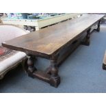 A 17th century style oak plank top refectory table on six baluster turned supports united by 'H'