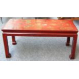 An early 20th century red lacquer gilt decorated rectangular coffee table on block supports,