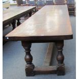 A 17th century style oak plank top refectory table on six baluster turned supports united by 'H'