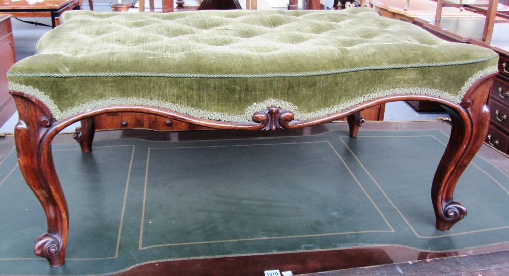 An early Victorian rosewood framed footstool of serpentine outline on cabriole supports,