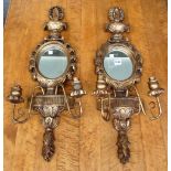 A pair of 18th century style gilt framed oval wall mirrors with urn finials and twin branch