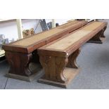 A pair of Victorian oak rectangular benches, each on double shaped slab end supports, 268cm wide.