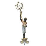 A 20th century painted figure of a blackamoor holding a torch on triform base, 108cm high.