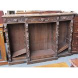A Victorian carved oak breakfront bookcase decorated with foliage and lion mask motifs,