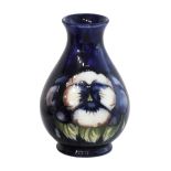 A Moorcroft pottery vase, early 20th century, decorated with pansies against a cobalt blue ground,