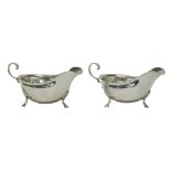 A pair of silver sauceboats, each with a shaped rim,