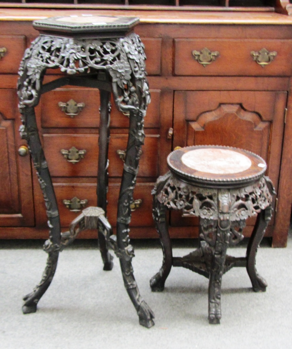 A late 19th century Chinese marble top carved hardwood urn stand, together with a similar smaller.