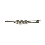 A diamond and cultured pearl bar brooch, mounted with the cultured pearl at the centre,