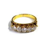 A gold and diamond set five stone ring, claw set with a row of circular cut diamonds,