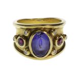 A gold, diamond, ruby and tanzanite set ring, collet set with the oval cut tanzanite at the centre,