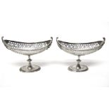 A pair of silver boat shaped bonbon stands, each with pierced decoration and on an oval foot,