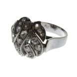 A diamond set cluster ring, pierced in an oval design, mounted with cushion shaped diamonds,