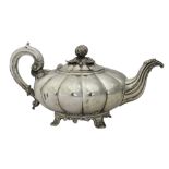 A George IV silver teapot, of compressed melon form, with fluted decoration,