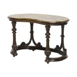 An early Victorian figured walnut kidney shaped free standing writing table on carved and scroll