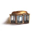 A gold,  aquamarine and pale blue gem set set three stone ring,