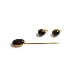 A gold and carbuncle garnet set single stone stick pin and a pair of carbuncle garnet set single