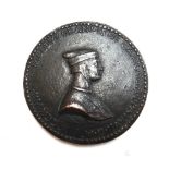 An unusual bronze medallion, relief cast with heraldic crest and profile bust,