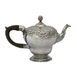 A George II silver teapot, of inverted pear shaped form, decorated with rococo scrolls and flowers,