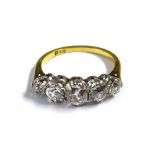 A gold and diamond set five stone ring, claw set with a row of cushion shaped diamonds,