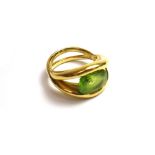 A gold and peridot set single stone ring, mounted with an oval cut peridot,