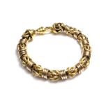 A two colour gold bracelet, in a Byzantine style link design, on a gold sprung hook shaped clasp,