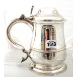 A George II silver hinge lidded tankard, of baluster form, with a scrolling handle,