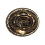 A Victorian oval pique tortoiseshell set brooch, decorated with floral motifs, with a case.