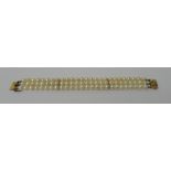 A three row bracelet of cultured pearls, on a rectangular gold clasp,