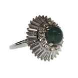 A cabochon emerald and diamond set ring, claw set with the oval cabochon emerald at the centre,