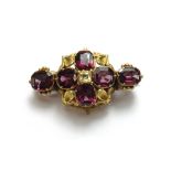 A gold, garnet and chrysolite set brooch, decorated with four trefoil shaped motifs at the centre,