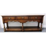 An 18th century style oak dresser base, with three frieze drawers on baluster turned supports,
