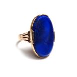 A gold ring, mounted with an oval simulated lapis lazuli between split shoulders, ring size O,