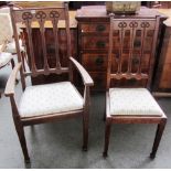 A set of six oak Arts and Crafts dining chairs with stylized motif carved backs on tapering square