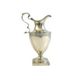 A George III silver cream jug of Adam style, with a scrolling handle,