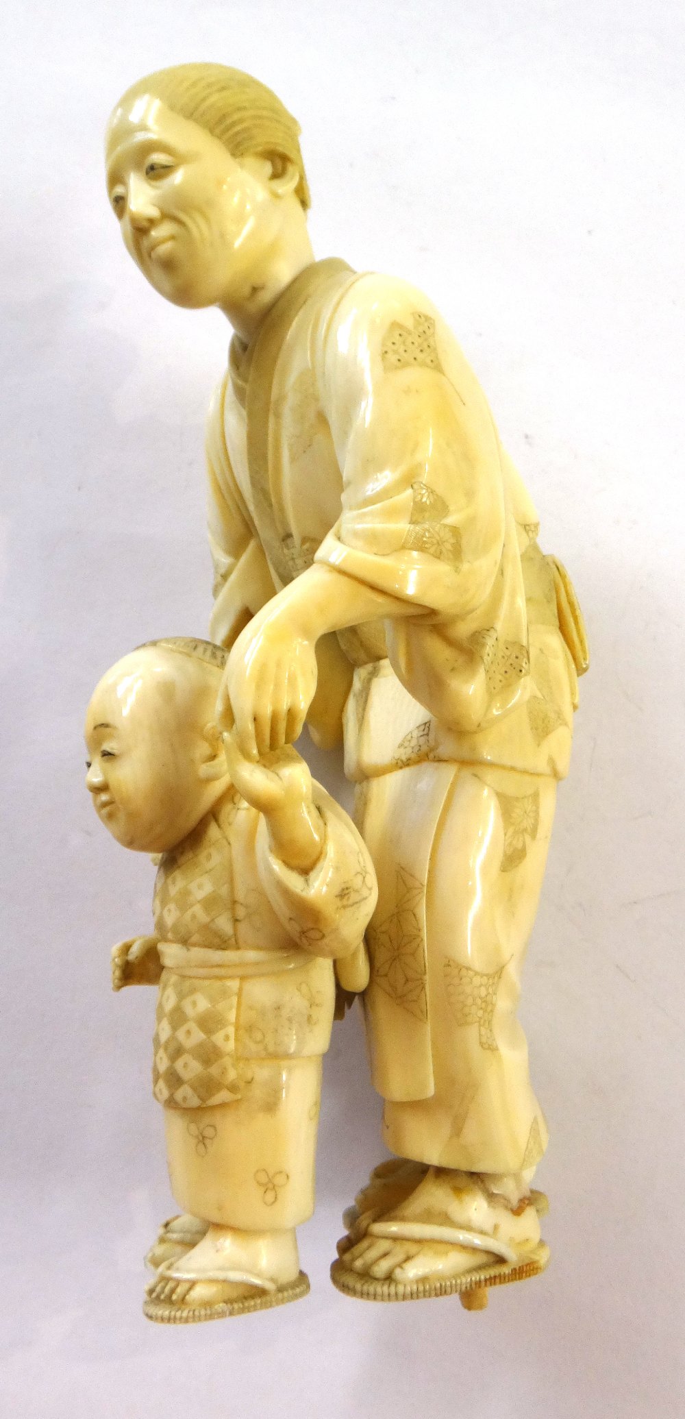 A Japanese ivory okimono of a woman helping a child to walk, Meiji period, - Image 8 of 12